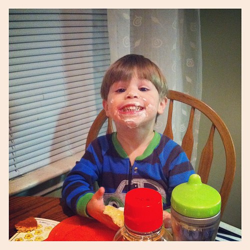 Enjoying whipped cream on his pancakes for dinner