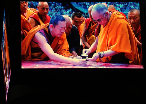 His Holiness the 14th Dalai Lama distributes sand from the Kalachakra Mandala to a lama, while others wait in line, Verizon Center, monitor, Kalachakra for World Peace, Washington D.C. USA by Wonderlane
