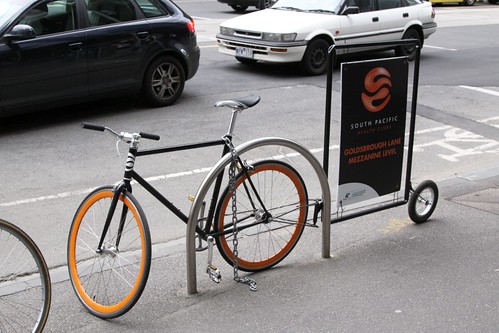 Bike with an advertising trailer, chained up to a bike rack