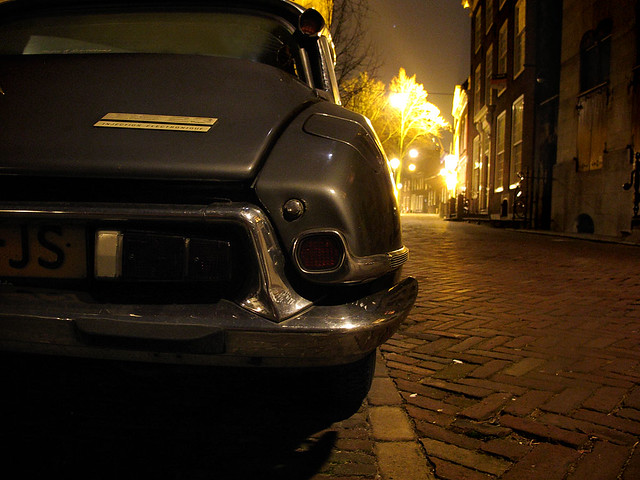 Night shot of an old Citroen DS that is parked near the old church of Delft