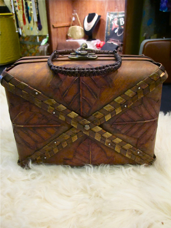 Rustic leaf-motif box bag with bronze strips and a woven handle