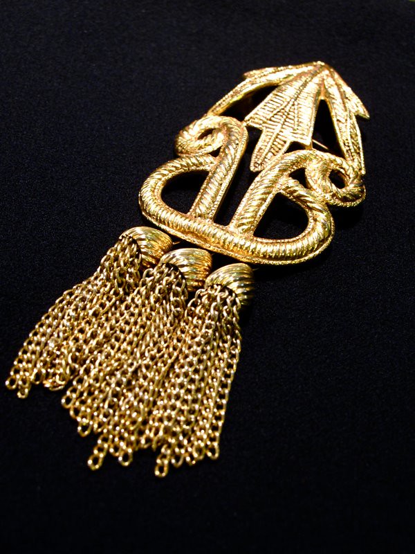 Shake it up with this  Dauplaise-signed gold-tone brooch with tassels!