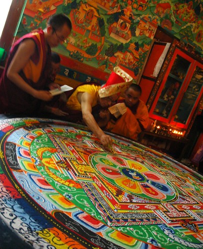 His Holiness Dagchen Rinpoche's holds a vajra drawing a line to close the colorful Shri Hevajra sand mandala, after the empowerment, monks assist holding books, mural, shrine, Tharlam Monastery of Tibetan Buddhism, Boudha, Kathmandu, Nepal by Wonderlane