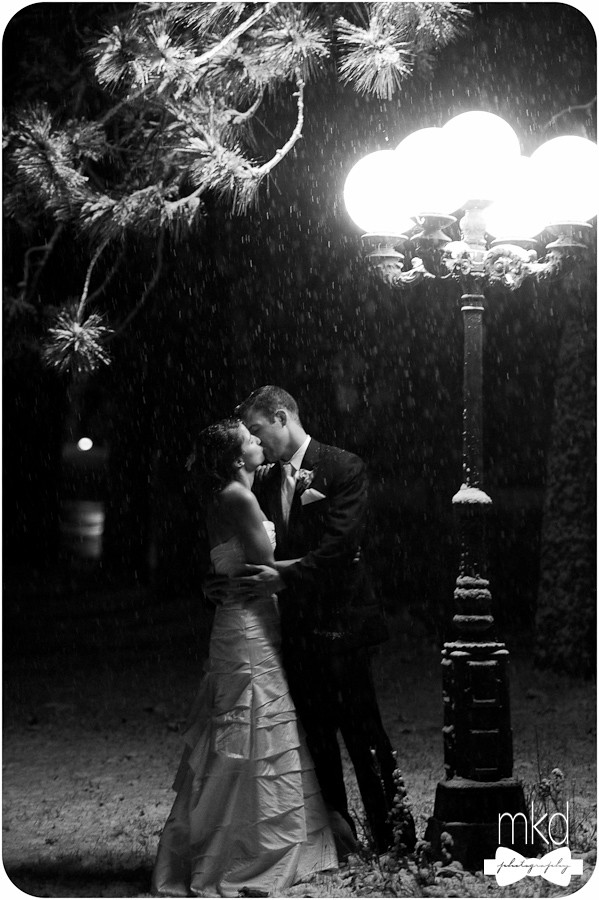 Kissing in the snow under an old fashioned street lamp