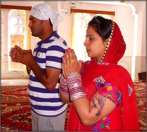 Sikh couple praying in the Gurdwara by Ginas Pics
