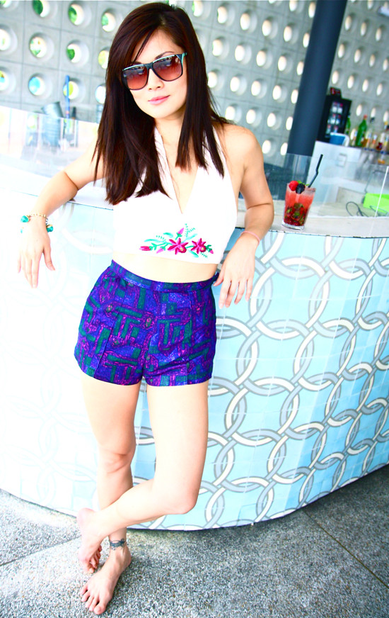 Chillin' by the bar in an embroidered 1970s halter top (S/M) worn with really cute high waist purple printed shorts (XS). A green beaded bracelet adds a jingly touch, and vintage sunglasses top it all off.