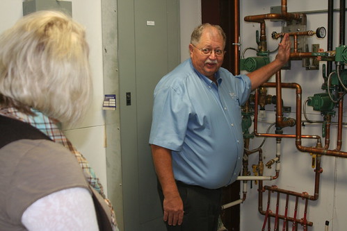 Seed company President Glen Davis explains to Business & Cooperative Program Director Dana Kleinsasser how the USDA-funded boiler heats the facility, saving 60 percent of the cost of energy.
