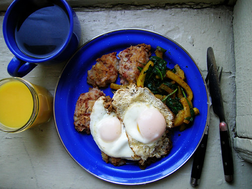 fried eggs on potato bean cakes, spinach, and peppers with coffee and OJ