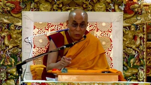How to get rid of negative emotions, His Holiness the Great 14th Dalai Lama gesturing, teaching live over the Internet Introductory Buddhist Teachings, Tibetan Buddhist monk, ornate symbolic throne, Main Tibetan Temple in Dharamsala, India by Wonderlane