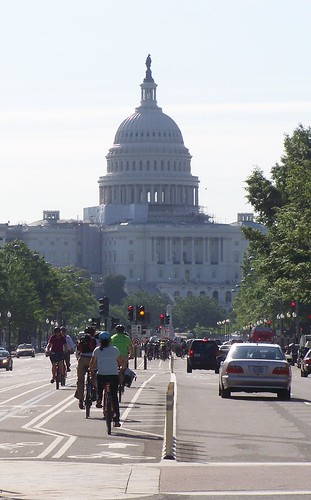 Bicyclists in the cycletrack on Pennsyvlania Avenue NW, Washington, DC, with the US Capitol in the foreground (cropped)