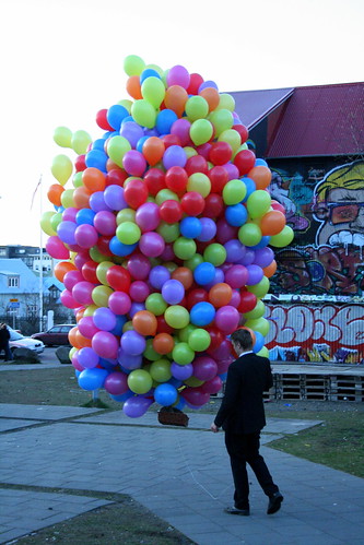 Man walks cat in basket under balloons, Reykjavik