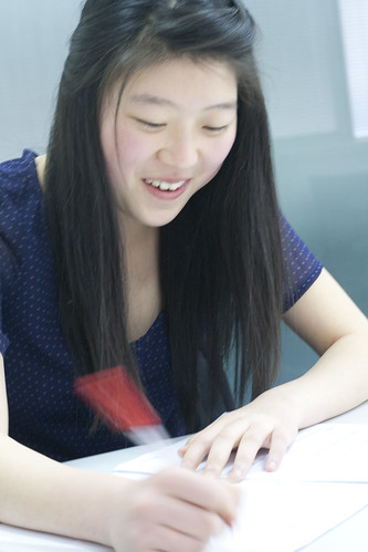 Student smiles as she corrects her paper