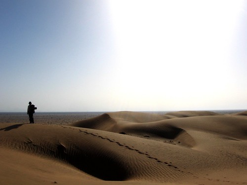 Silhouette of a walker atop sand dune in the Wahiba