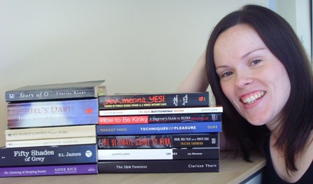 Catherine next to a stack of BDSM books
