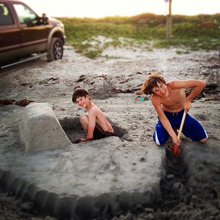 Making a sand fort. With a moat. For defenses at the beach.