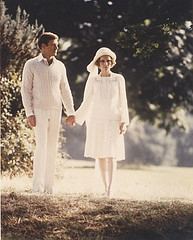 screen shot from the Great Gatsby movie showing a couple dressed all in white walking on a road