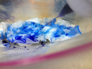 Squirting blue dye onto the white silk