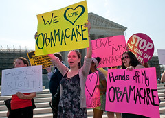 women with pro-Obamacare posters outside the Supreme Court