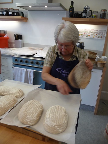 Carefully getting sourdough from basket to tray