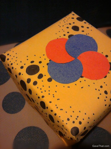 Simple dots form a pin wheel embellishment on the top of gifts in this easy DIY gift wrapping look