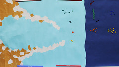 Fish Banks遊戲地圖。深藍色區域為深海，淺藍色為沿海，峽灣內代表港口，磁鐵代表漁船，依照顏色不同代表不同船隊。遊戲初期大家都集中在深海捕撈。