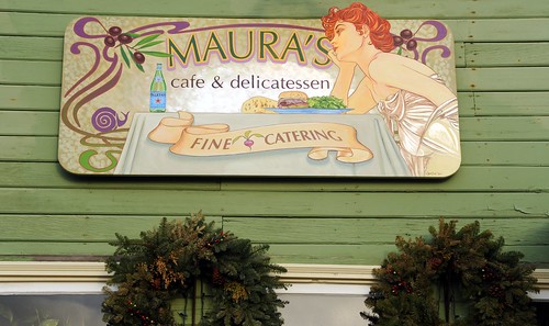 Maura's cafe & delicatessen, fine catering, red headed woman at a table, olives, snail, art nouveau sign, wreaths, old town, Homer, Alaska, USA by Wonderlane
