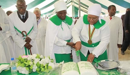 Zimbabwe Vice President Joice Mujuru cuts a cake while Apostolic Faith Church Bishop Mika Mutangamidzwa and his wife Peggy Mungwariri look on at the church’s Centenary celebrations in Mhondoro on June 14, 2013. by Pan-African News Wire File Photos