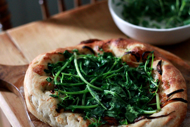 pizza topped with spring greens