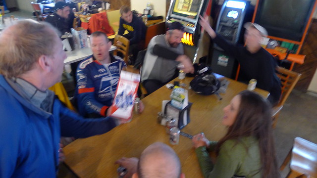 Blurry, downward view of people sitting around a table, inside a bar