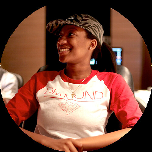 Wondagurl - a young black woman with a baseball cap and big smile - relaxes in a recording studio