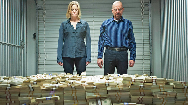 Skyler and Walt look down at a giant pile of money