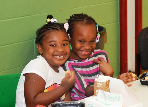 Two little girls enjoy a nutritious meal at one of the Philadelphia Archdiocese’s Nutritional Development Services 450 summer food service sites.
