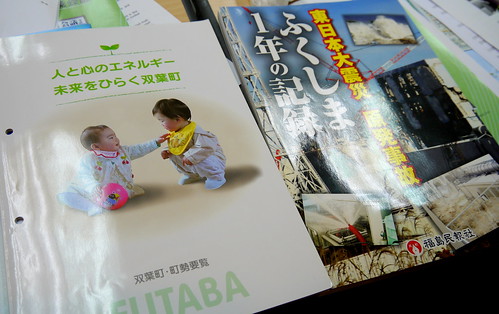 福島核電廠的文宣與核災慘狀照片集相對照，相當諷刺。