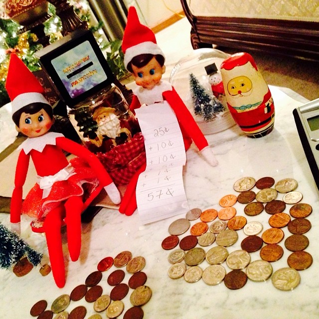 Elfie and Samantha Elf are back home from being at Grandma's for part of this week... The elves decided to play with the kids piggy bank money and made two hearts out of the coins. Elfie even got out the calculator and added up some coins. #hisugarplumelf