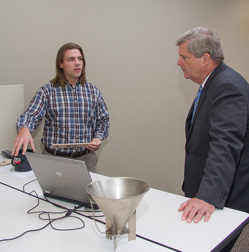 TSD engineer Jason Jordon demonstrated to Secretary Vilsack the proper method for leveling off grain in the kettle used to measure test weight.