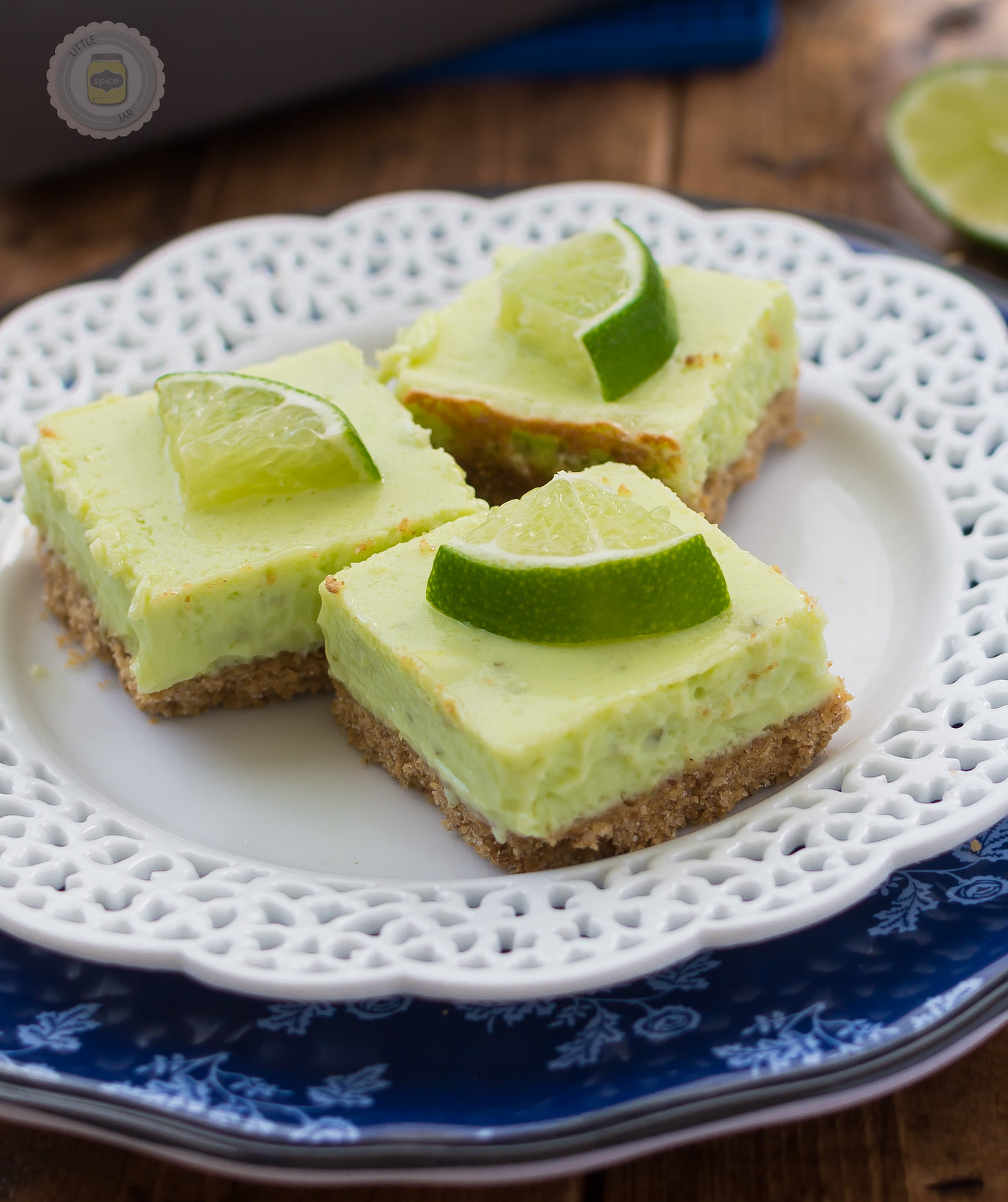 stacked plates with key lime pie squares resting on doily plate