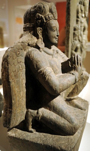 Statue of Vajra Guruda, kneeling winged male figure with headdress, crown, jewels, earrings, snake necklace, stone, hands clasped in prayer mudra, Chicago Art Institute, Chicago, Illinois, USA by Wonderlane
