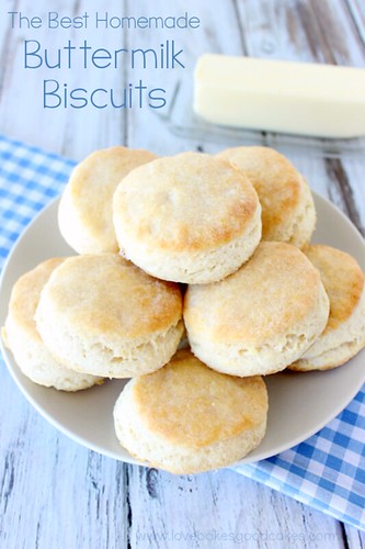 The BEST Homemade Buttermilk Biscuits stacked up on plate with a stick of butter.