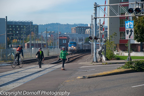 The Coast Starlight leaving Portland with skateboarders along tracks. by Dornoff Photography