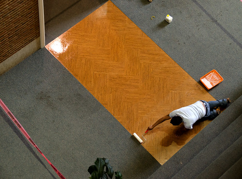 Worker Applying Sealant to Cork Floor Mockup
