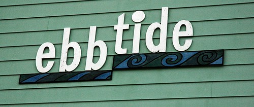 ebb tide, sign, waves, similar to TIbetan symbol for "Everyone in existence now here this!", siding, Anchorage, Alaska, USA by Wonderlane