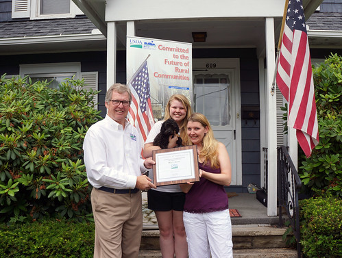 Thomas Williams, USDA Rural Development State Director for Pennsylvania presents a Certificate of Appreciation to Misty Allen, her daughter Deanna and their new puppy Odee for National Homeownership Month. Ms. Allen's new mortgage is less than she previously paid in rent.  (USDA Photo)