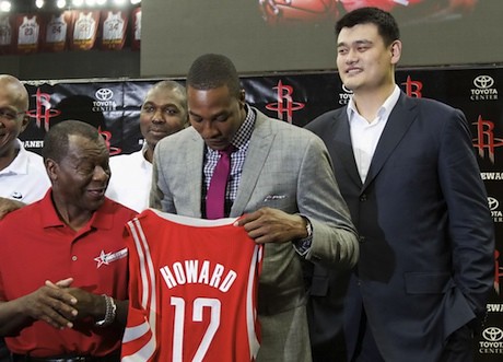 July 13, 2013 - Yao Ming stands behind Dwight Howard as he holds up his jersey.  Former Rocket Calvin Murphy looks on.