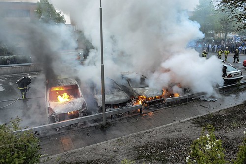 Firemen extinguish a row of burning cars in the Stockholm suburb of Rinkeby after youths rebelled in several different suburbs around Stockholm for a fourth consecutive night, late May 23, 2013. by Pan-African News Wire File Photos