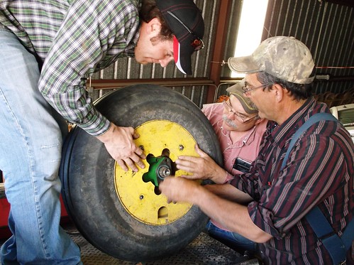 Kurt, Carl, and Dad fix a wheel on the planter