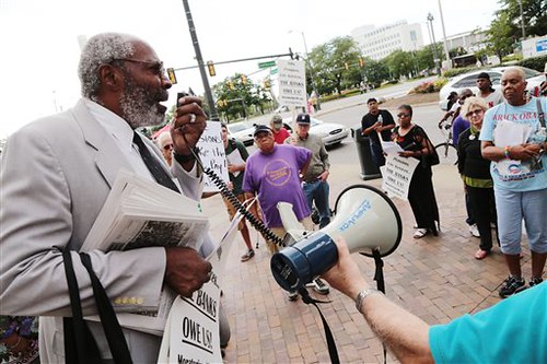 Abayomi Azikiwe of the Moritorium Now Coalition talks with protestors gathered outside of the Coleman A. Young Municipal Center in downtown Detroit on Friday July 26, 2013 while opposing to pension cuts.  by Pan-African News Wire File Photos