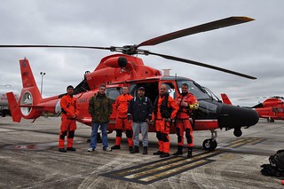 Two survivors from a vessel with stability issues in the Gulf of Mexico take a photo with the Coast Guard Air Station New Orleans aircrew who rescued them and transported them to the air station in Belle Chasse, La., Nov. 26, 2013. The vessel began experiencing stability issues Monday, about 30 miles offshore of Mobile, Ala. (U.S. Coast Guard photo by Air Station New Orleans)