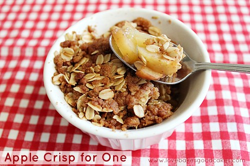 Apple Crisp for One in white bowl with bite on spoon showing ingredients. 