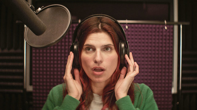 Lake Bell's Carol in a voice booth, wearing headphones