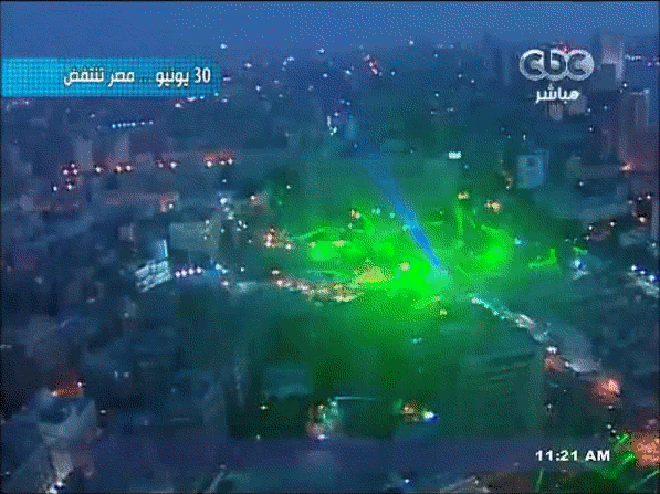 Large animated GIF taken from the air showing tens of green laser beams lightening the space above protesters in Tahrir.